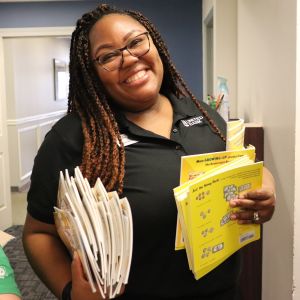 Photo of AALC volunteer holding books to sort during the Book Drive