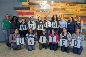 Photo of Women United at Lowcountry Food Bank. Members are holding letters that spell out Women United
