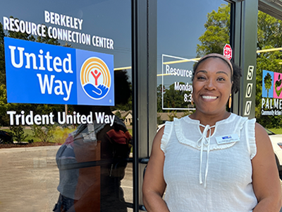 Woman standing outside of the Berkeley Resource Connection Center, next to the United Way logo on the door