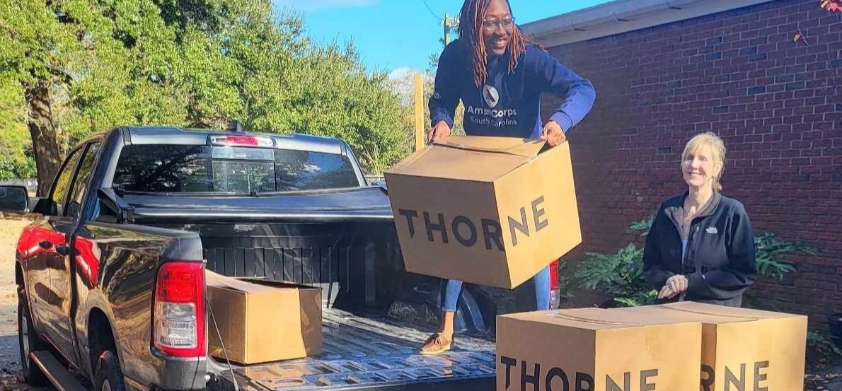 AmeriCorps members moving Thorn Boxes off a truck.