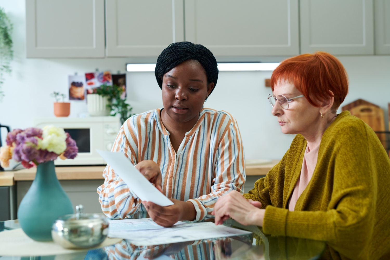 Woman holding a piece of paper and pointing to paper while second woman looks on