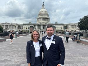 Two individuals wearing business suit in front the of the US Capitol