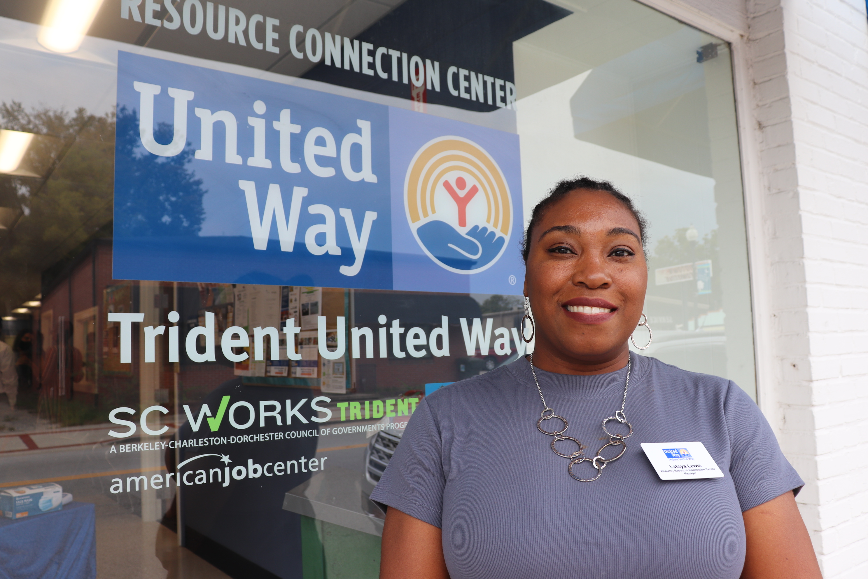 Latoya Lewis smiling in front of the TUW RCC sign
