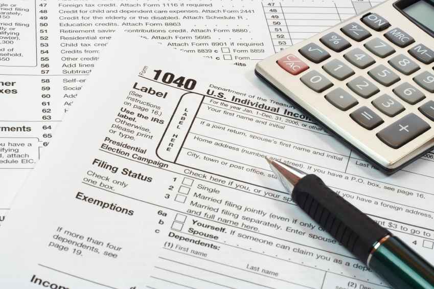 Photo showing a 1040 for taxes, calculator and pen