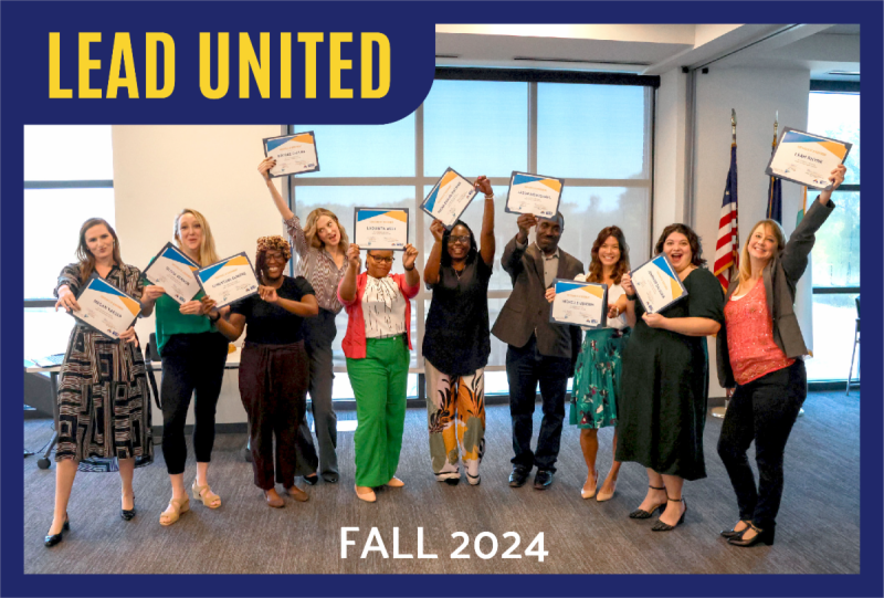 Lead United graduates holding diplomas up in the air with excitement