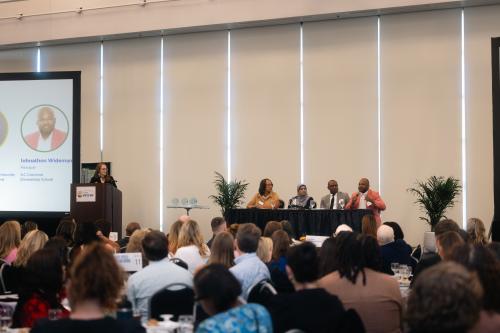 Wide shot of State of Our Families event with moderator and panelists