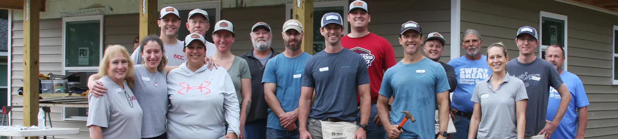 A group of individuals posing for a photo at a habitat for humanity site