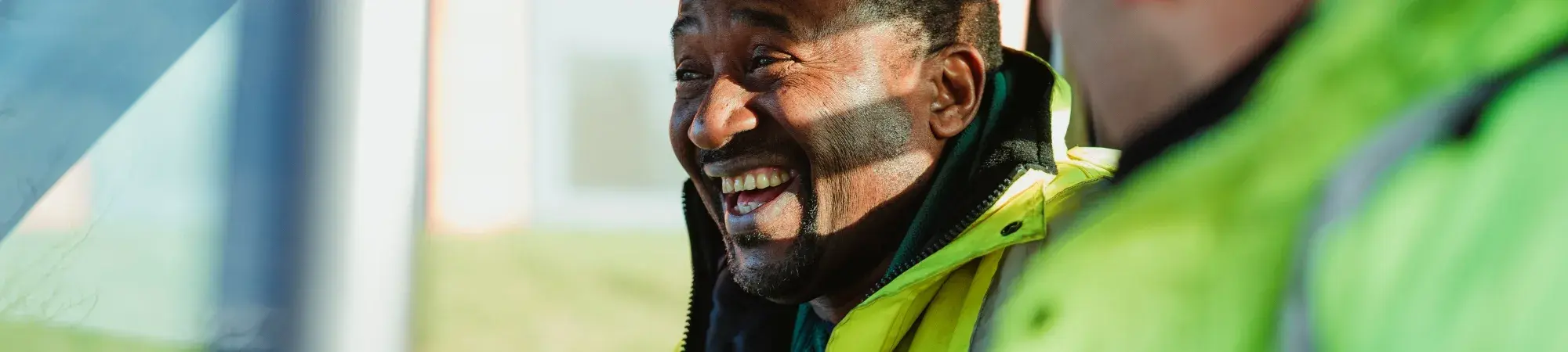 A constrution worker smiling driving truck