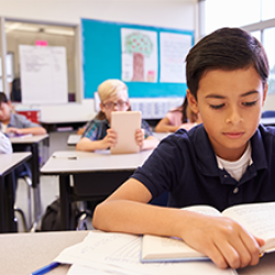 boy reading a book in school