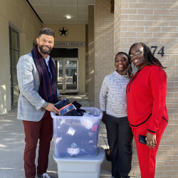 Volunteers stand next to donated goods outside of Star Gospel Mission's building for their expanded Morning Light Program